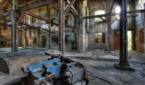 Alte Fabrikhalle mit Rost, Holz und zerfallenden Wauern.
